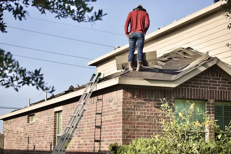 Professional roofer working on a residential roof in Wood